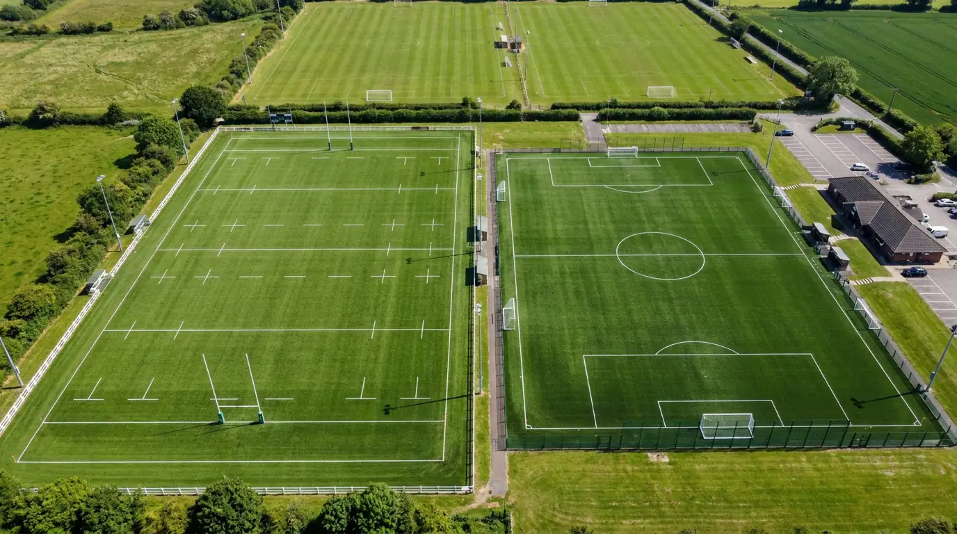 Adjacent rugby and football pitches visible from above showing the size difference