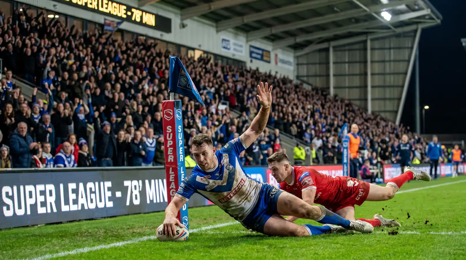 Rugby league player scoring a try under the posts during a Super League match