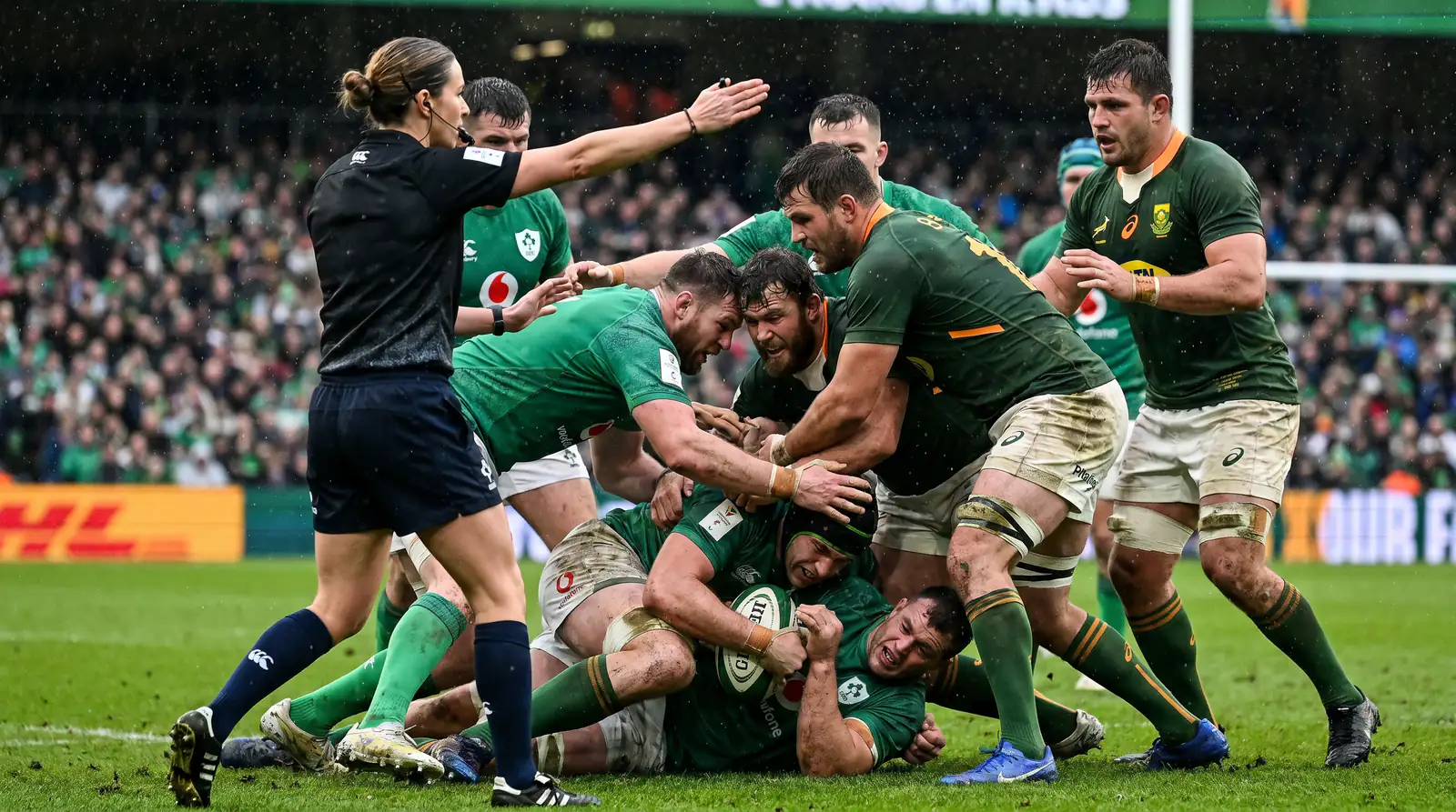 Rugby referee overseeing a contested breakdown with players competing for the ball