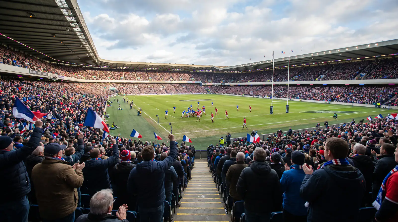 Packed rugby stadium with fans cheering during an international match